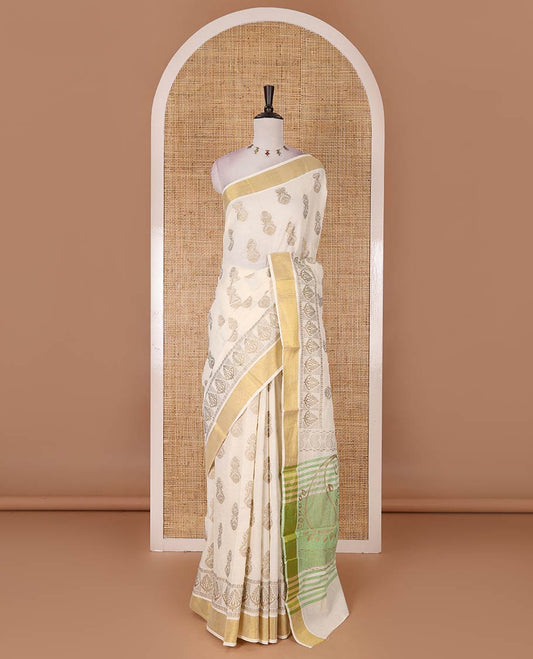 Cream Mughal-style buttas, golden foil printed Kerala cotton saree, zari border, pallu of paisley motifs, and a matching blouse