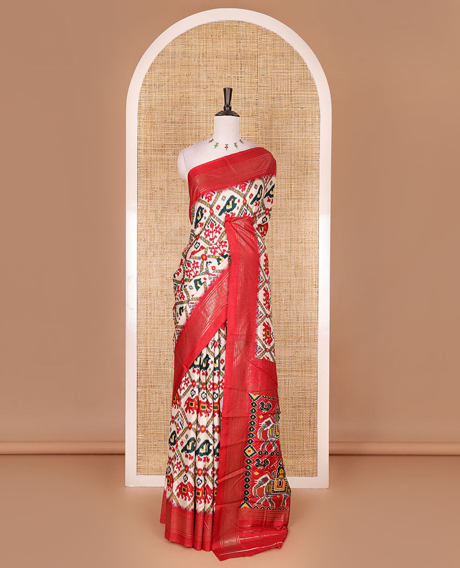 Half-white and red buttas enclosed jaal patterned patola-inspired pochampally dola silk saree, contrast red zari border, patola elephant pallu, and contrast blouse