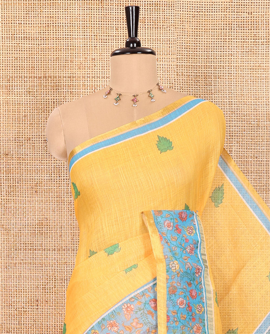 Yellow Linen Saree Detailed with Leaf Motifs All Over Its Body, Complemented by a Contrast Floral Vine Printed Border, Pallu Mirrors the Floral Vine Print, and Paired with a  Contrast Floral Printed Blouse