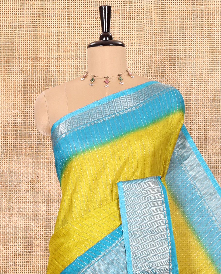 Green Dola Silk Saree Subtly Sparked with Vertical Golden Stripes Running All Over Its Body, Complemented by a Contrast Traditional Zari Design Woven Border, Subtly Striped Pallu, and a Contrast Buttas Woven Blouse