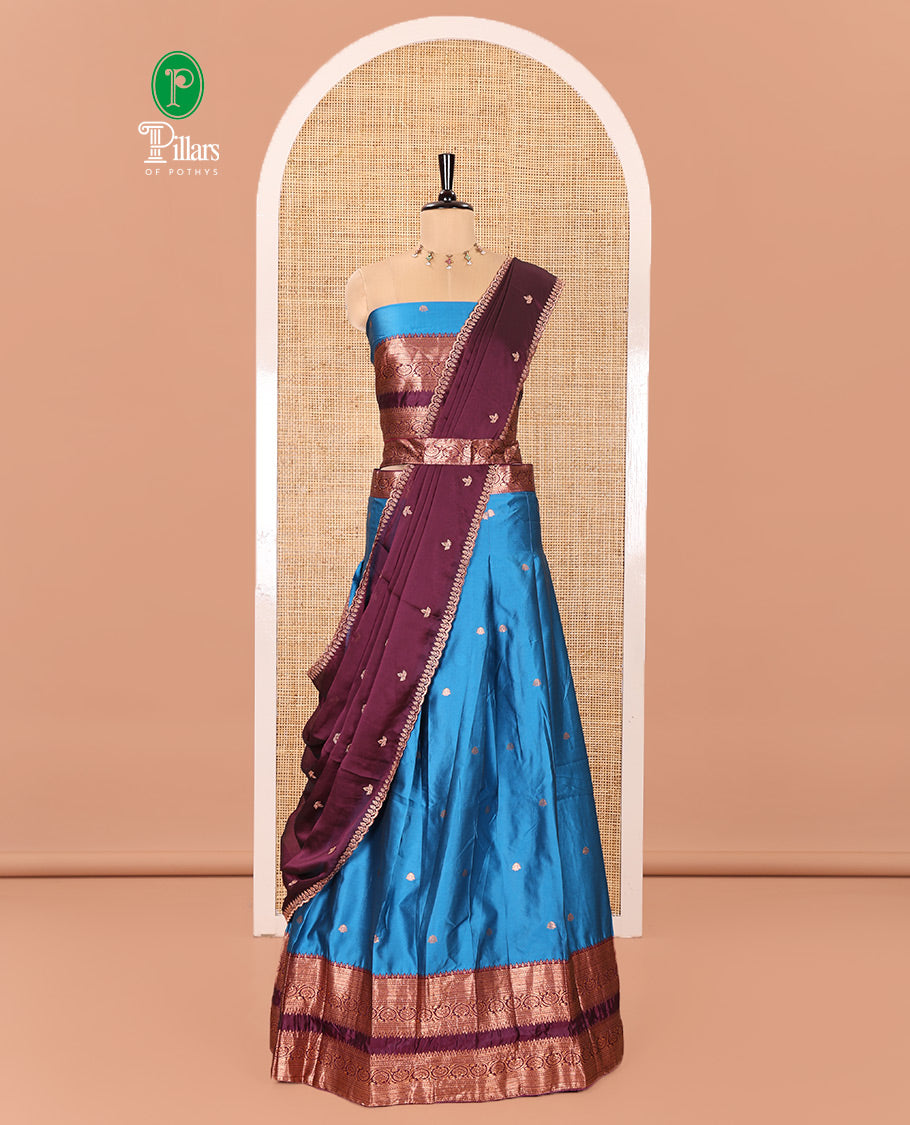 Blue and Purple Semi-Banarasi Half-Saree Featuring Zari Buttas Skirt, Complemented by Contrast Rettai Pettu, Traditional Border of Floral Creeper Designs, Paired with a Matching Blouse, and a Satin Georgette Embroidered Scallop Dhavani