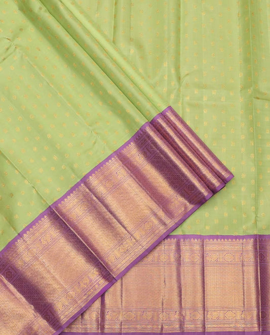 Green Pure Silk Half-Saree, Artfully Detailed with Mayil-Chakram Buttas on Its Skirt, Complemented by a Contrast Border of Rekku, Muthu, Diamond, Chakram, and Jaal Designs, Comes with a Contrast Blouse and a Dhavani of Jacquard Design