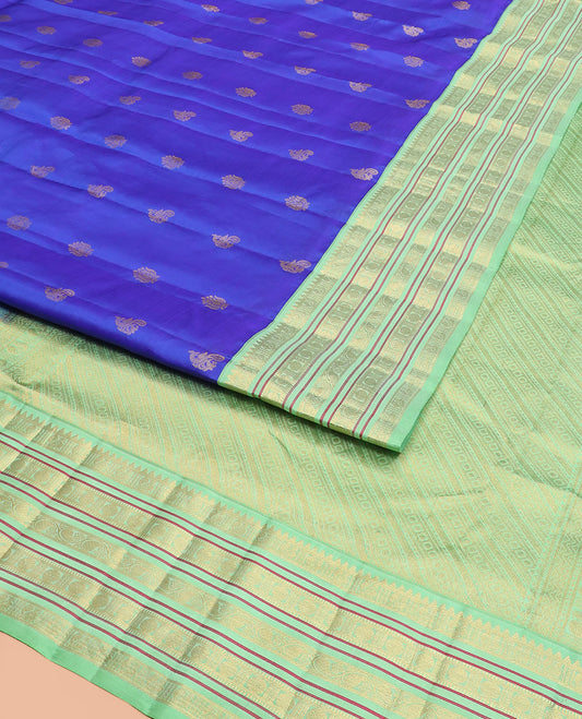 Royal Blue Vasundhara Silk Saree Subtly Woven with Zari Buttas, Complemented by a Contrast Varisai Pettu Border of Rekku, Mayil, Rudraksham, and Manga Designs, Pallu Adorned with Traditional Designs, and Paired with a Contrast Zari-Bordered Blouse