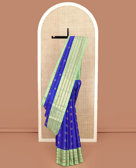 Royal Blue Vasundhara Silk Saree Subtly Woven with Zari Buttas, Complemented by a Contrast Varisai Pettu Border of Rekku, Mayil, Rudraksham, and Manga Designs, Pallu Adorned with Traditional Designs, and Paired with a Contrast Zari-Bordered Blouse