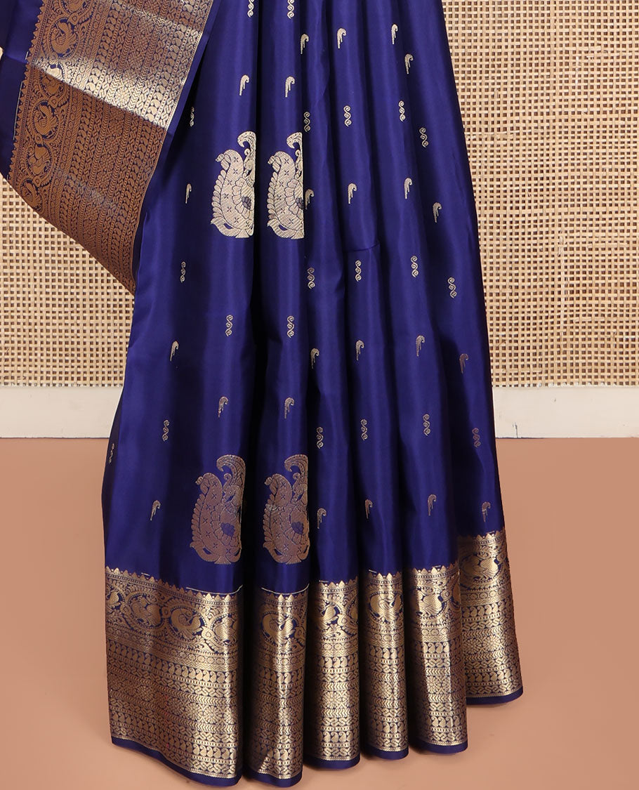 Blue Vasundhara Silk Saree, Decorated with Zari Buttas All Over Its Body, Highlighted by Zari Border of Rekku, Muthu, Mayil, Manga, Muthu, Kathir, Laddu Kamalam, and Cross Neli Designs, Pallu Mirrors the Same Designs, and Paired with a Matching Blouse