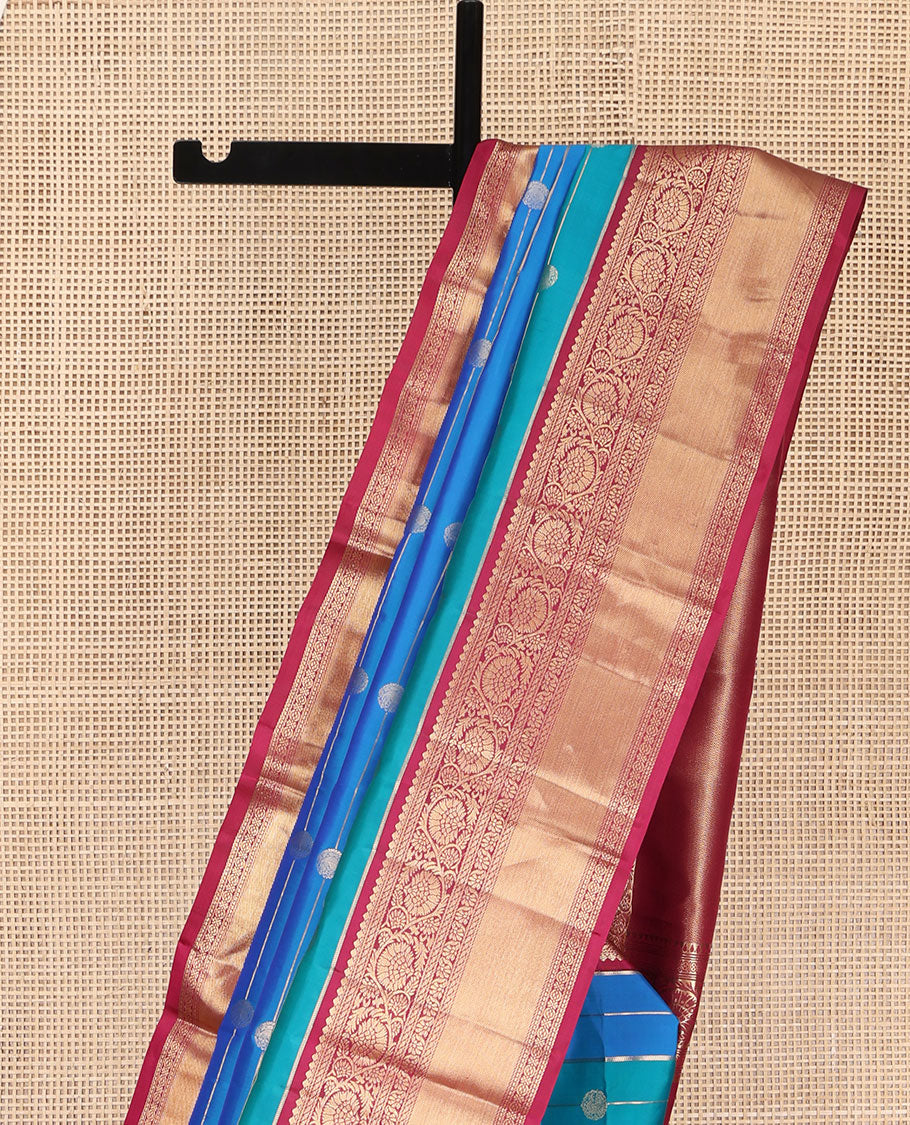 Blue Vasundhara Silk Saree, Impeccably Styled with Zari Buttas and Zari Stripes All Over Its Body, Complemented by a Contrast Border of Salngai, Puli Nagam, and Kodi Visiry Designs, Grand Gleaming Zari Woven Pallu, and Paired with a Contrast Blouse