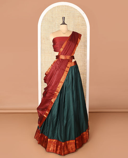 Dark green art-silk half-saree, plain with contrast temple traditional design bordered skirt, contrast blouse, and plain zari bordered dhavani