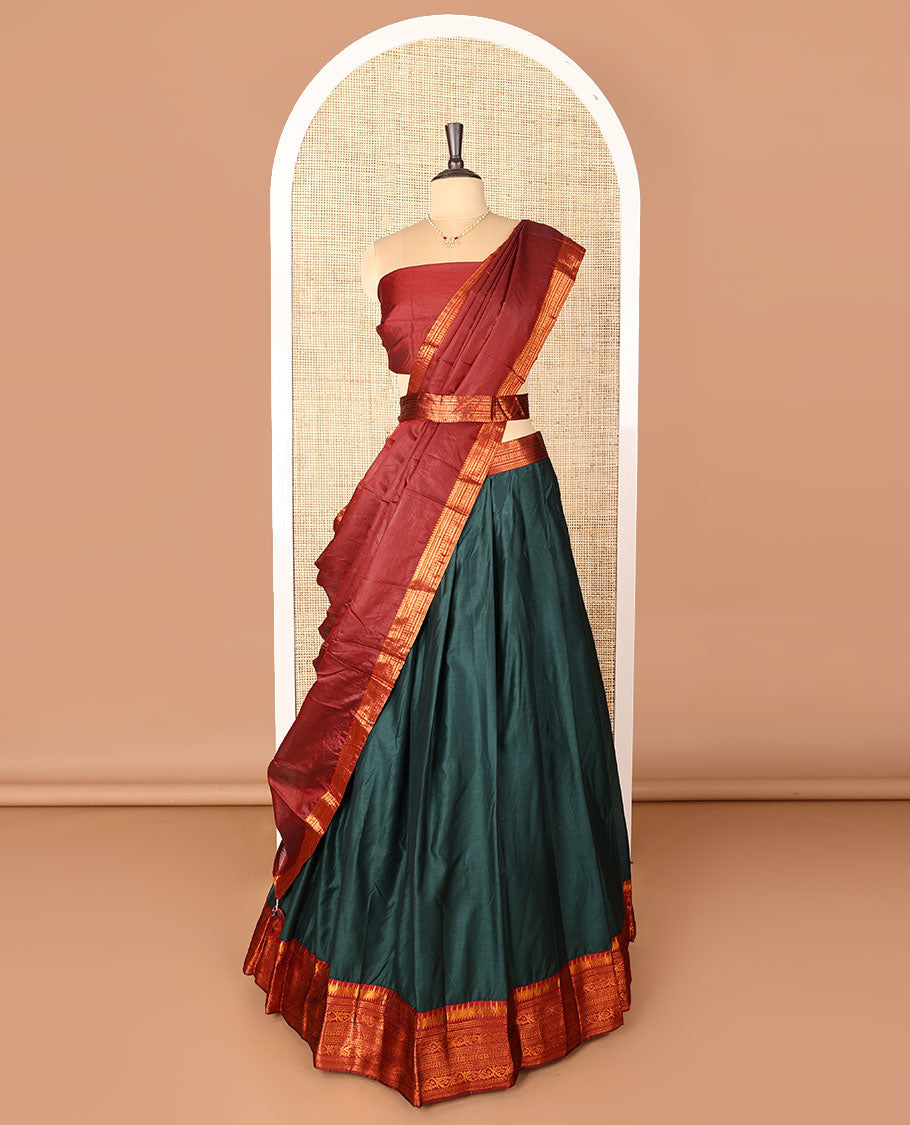 Dark green art-silk half-saree, plain with contrast temple traditional design bordered skirt, contrast blouse, and plain zari bordered dhavani