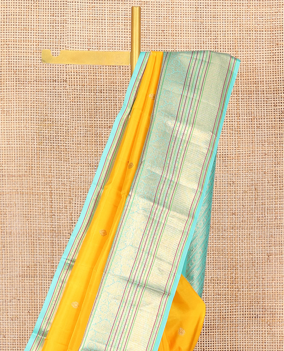 Yellow Vasundhara Silk Saree Decorated with Zari Buttas All Over Its Body, Complemented by a Contrast Border of Leaf, Rudraksham, Diamond, and Mayil Kann Designs, Pallu Featuring Manga Creeper Designs, and Paired with a Contrast Blouse