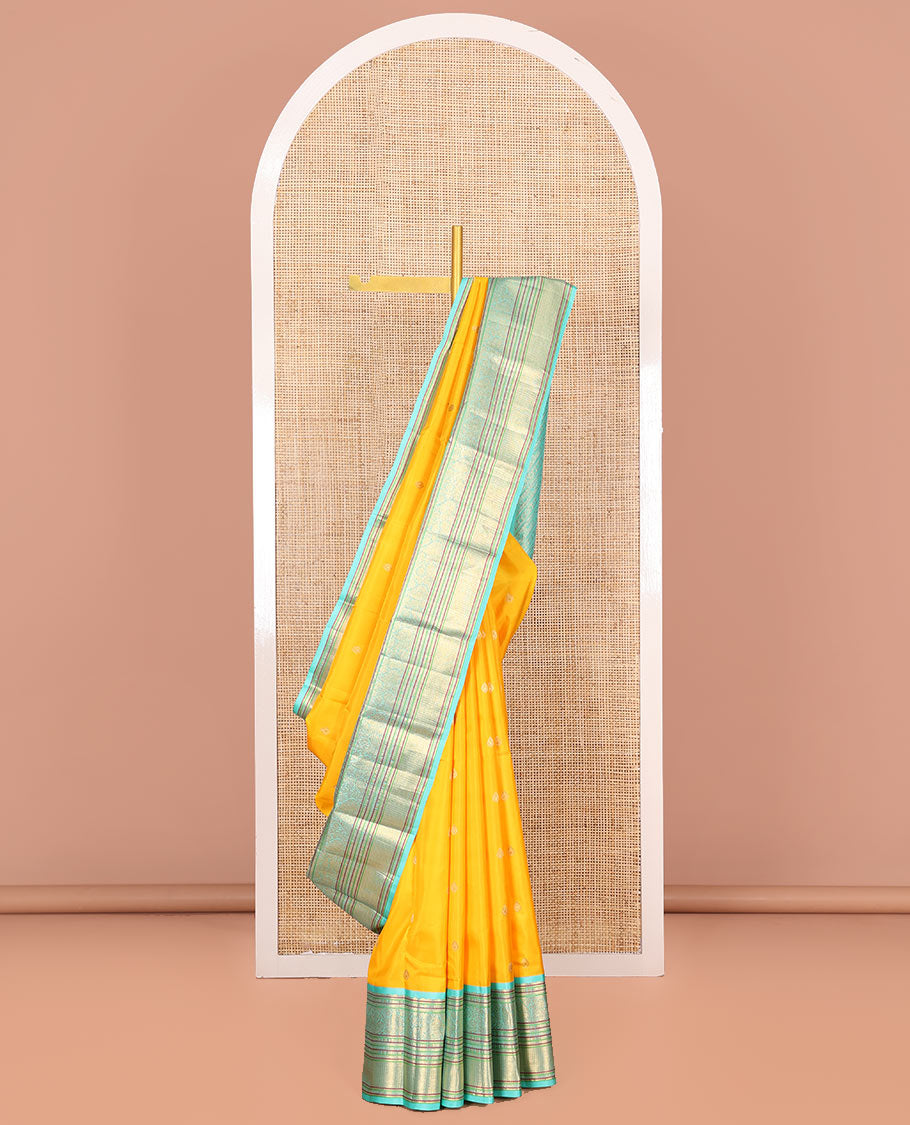 Yellow Vasundhara Silk Saree Decorated with Zari Buttas All Over Its Body, Complemented by a Contrast Border of Leaf, Rudraksham, Diamond, and Mayil Kann Designs, Pallu Featuring Manga Creeper Designs, and Paired with a Contrast Blouse