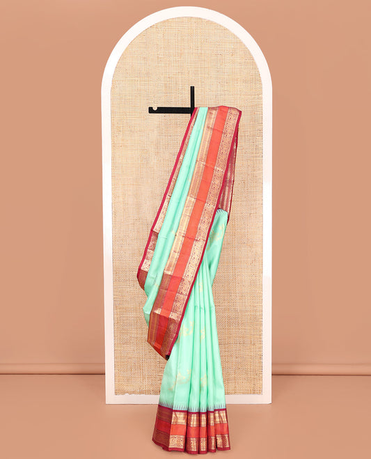 Turquoise Vasundhara Silk Saree, Meticulously Crafted with Zari Buttas on Its Body, Complemented by Contrast Border of Muthu, Mayil Kann, Chakram, Mayil, and Kuthirai Designs, an Intricately Designed Pallu, and Paired with a Contrast Blouse