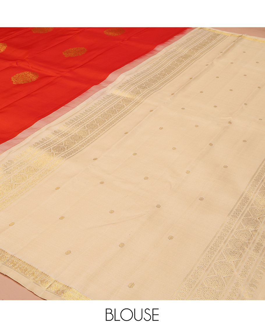 Orange Kanchipuram Silk Saree, Beautified with Zari Buttas All Over Its Body, Subtle Zari Piping Border, Complemented by a Contrast Pallu of Traditional Zari Designs, and Paired with a Contrast Blouse