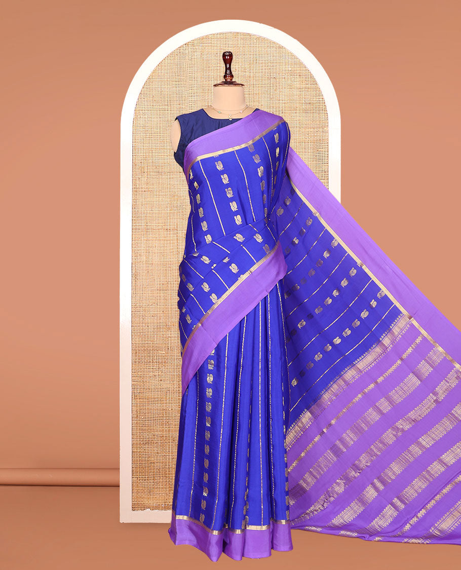 Blue Mysore Silk Saree, Gracefully Decked Up with Peacock Buttas and Stripes Across Its Body, Complemented by Contrast Border, Pallu Steeped with Traditional Zari Designs, and Paired with a Contrast Blouse