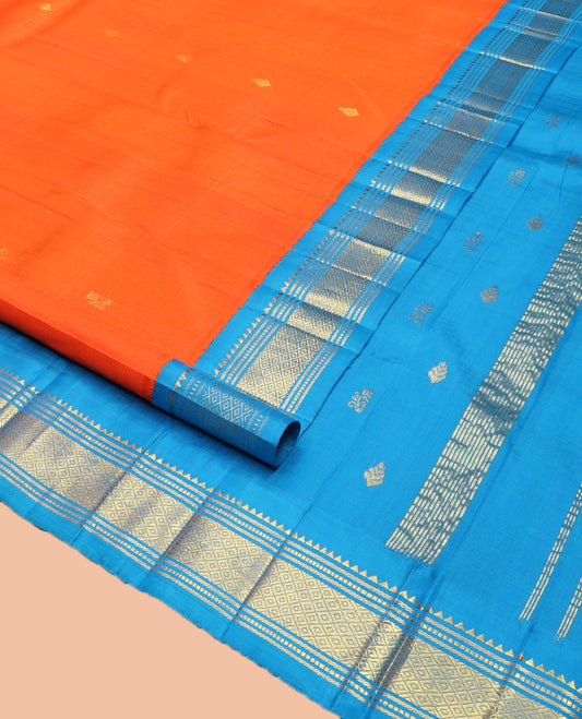 Orange Kanchipuram Silk Saree, Subtly Enriched with Zari Buttas on Its Body, Complemented by Contrast One-Sided Korvai Border of Rekku, Banaras, Muthu, and Mayil Kann Designs, Pallu Depicts Zari Designs, and Comes Without a Blouse