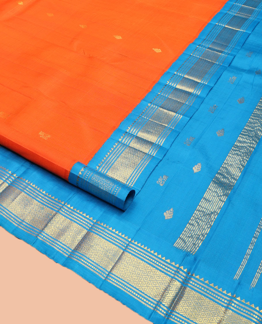 Orange Kanchipuram Silk Saree, Subtly Enriched with Zari Buttas on Its Body, Complemented by Contrast One-Sided Korvai Border of Rekku, Banaras, Muthu, and Mayil Kann Designs, Pallu Depicts Zari Designs, and Comes Without a Blouse