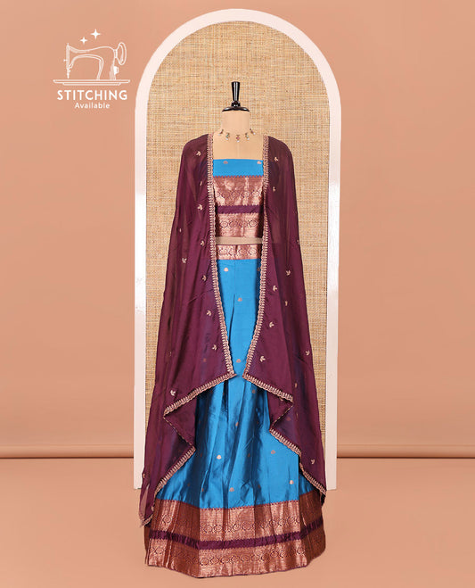 Blue and Purple Semi-Banarasi Half-Saree Featuring Zari Buttas Skirt, Complemented by Contrast Rettai Pettu, Traditional Border of Floral Creeper Designs, Paired with a Matching Blouse, and a Satin Georgette Embroidered Scallop Dhavani