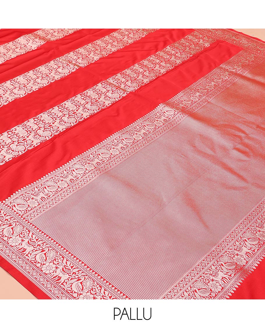 Red Mushuru Silk Saree, Gracefully Embellished with Vertically Woven Flora-Fauna Zari Designs On Its Body, Highlighted by Zari Border of Peacock and Deer Motifs, Grand Pallu, and Paired with a Plain Blouse
