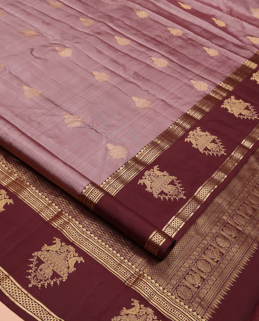 Pale Brown Vasundhara Silk Saree, Finely Crafted with Zari Buttas All Over Its Body, Complemented by Contrast Border of Thilakam Mokku, Neli, Kili, Yaanai, and Ara Maadam Designs, Grand Pallu and Paired with a Contrast Blouse