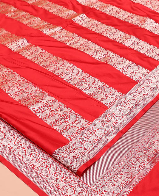 Red Mushuru Silk Saree, Gracefully Embellished with Vertically Woven Flora-Fauna Zari Designs On Its Body, Highlighted by Zari Border of Peacock and Deer Motifs, Grand Pallu, and Paired with a Plain Blouse