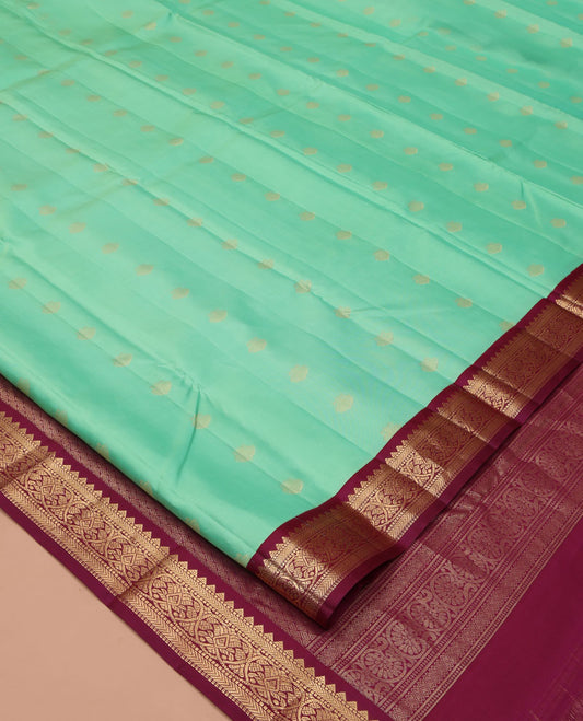 Light Turquoise Vasundhara Silk Saree, Sparsely Woven with Zari Buttas All Over Its Body, Complemented by a Contrast Border of Rekku, Muthu, Kathir, and Kodi Visiry Designs, Grand Jaal Pallu, and Paired with a Contrast Blouse