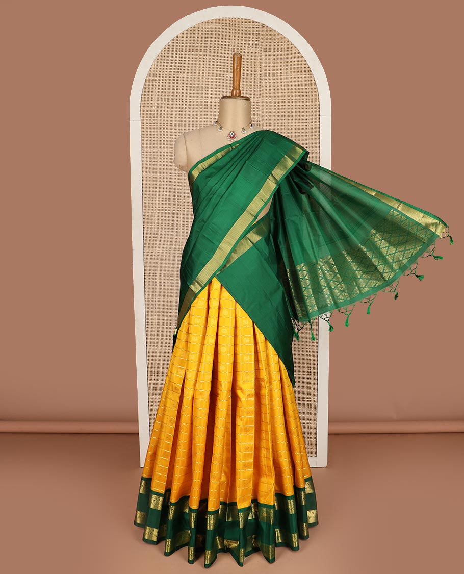 Yellow pure silk half saree, mayil chakram enclosed neli checked skirt, contrast rettai pettu border and blouse of thilakam mokku, muthu, mayil and yaali design and intricate pallu