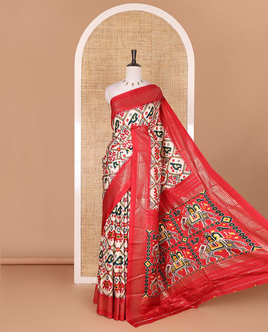 Half-white and red buttas enclosed jaal patterned patola-inspired pochampally dola silk saree, contrast red zari border, patola elephant pallu, and contrast blouse