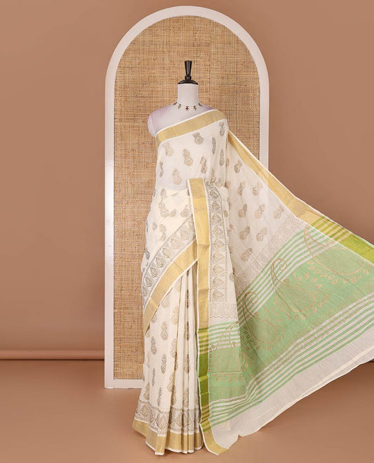 Cream Mughal-style buttas, golden foil printed Kerala cotton saree, zari border, pallu of paisley motifs, and a matching blouse