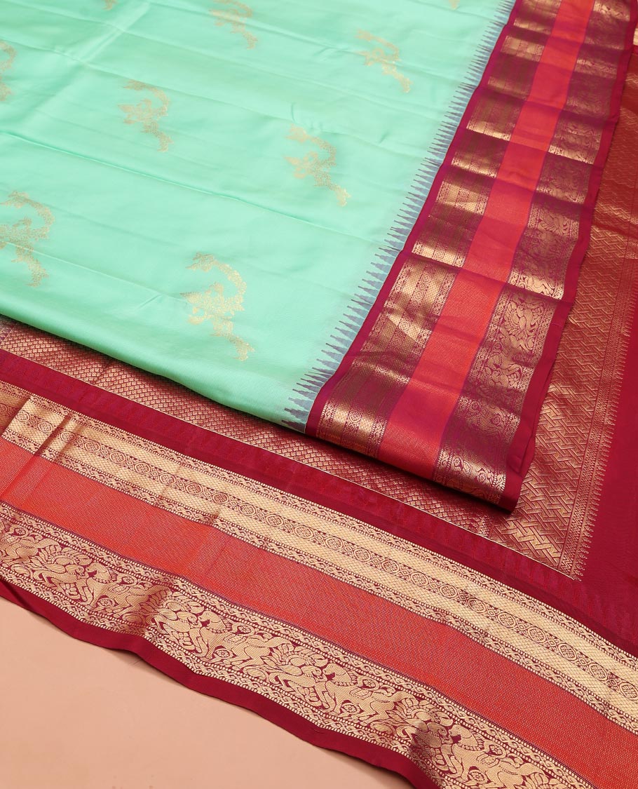 Turquoise Vasundhara Silk Saree, Meticulously Crafted with Zari Buttas on Its Body, Complemented by Contrast Border of Muthu, Mayil Kann, Chakram, Mayil, and Kuthirai Designs, an Intricately Designed Pallu, and Paired with a Contrast Blouse