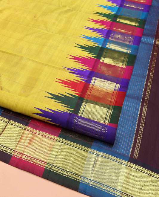 Yellow Kanchipuram Silk Saree, Subtly Sparkled with Zari Buttas, Complemented by Contrast Multi-Colored One-Sided Thazampoo Rekku Border of Zari Designs, Pallu Steeped with Vaira Oosi Stripes, and Comes Without a Blouse