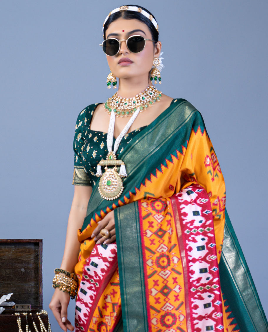 Orange patola floral motifs designer saree, contrast temple border, and patola printed pallu