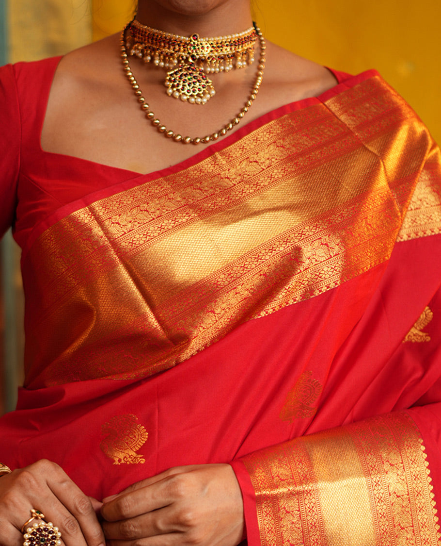 Red Budget Silk Saree, Gleamed Up with Zari Buttas on Its Body, Highlighted by a Zari Border of Traditional Designs, Grand Jaal Design Border, and Paired with a Matching Blouse