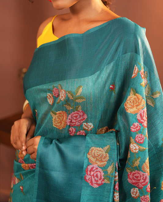 Rama Blue Green-Silk Saree, Colorfully Highlighted with Rose Motifs Cross Stitch Embroidery on Its Body, Subtly Sparkled by a Plain Border, Pallu of Rose Cross Stitch Embroidery, and Paired with a Contrast Blouse