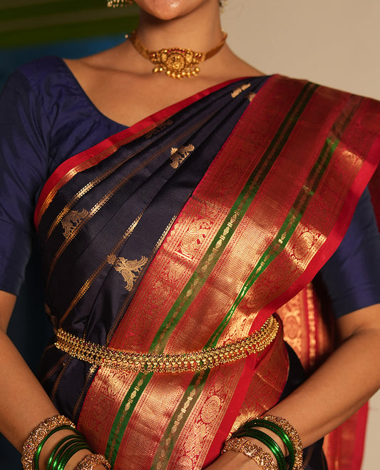 Blue Vasundhara Silk Saree, Accentuated with Zari Buttas and Stripes All Over Its Body, Complemented by a Contrast Border of Elephant, Mayil, and Chakram Designs, a Grand Pallu, and Paired with a Contrast Blouse