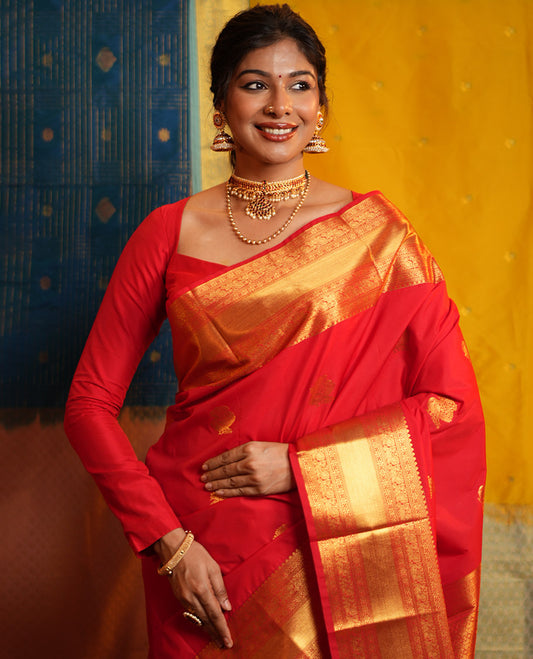 Red Budget Silk Saree, Gleamed Up with Zari Buttas on Its Body, Highlighted by a Zari Border of Traditional Designs, Grand Jaal Design Border, and Paired with a Matching Blouse
