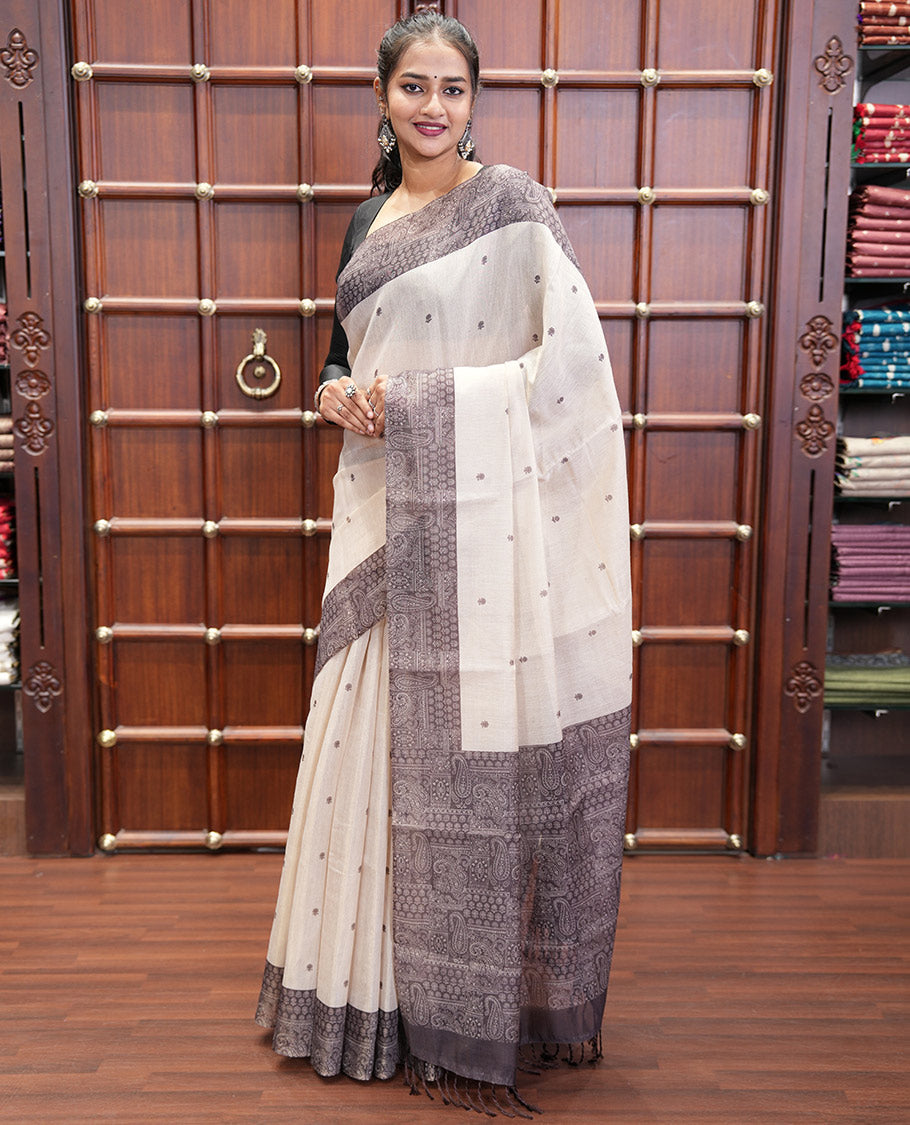 Chikku and Black Tissue Linen Saree, Delicately Printed with Floral Motifs on Its Body, Complemented by a Contrast Border of Paisley Designs, Pallu Steeped with Paisley Designs, and Paired with a Contrast Blouse