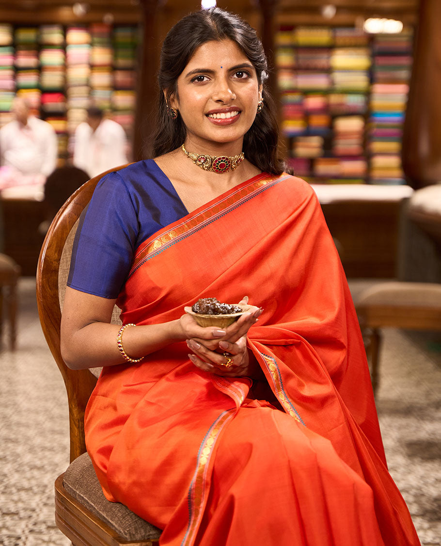 Red kancheepuram silk saree with self border of thilakam mokku, paun design & striped pallu