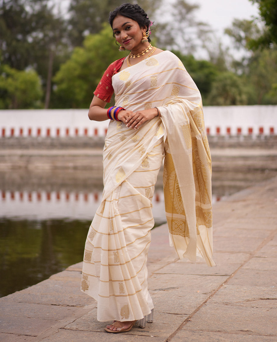 Cream Kerala Cotton Saree, Delicately Woven with Zari Stripes and Buttas, Highlighted by an Intricate Pallu and a Matching Blouse