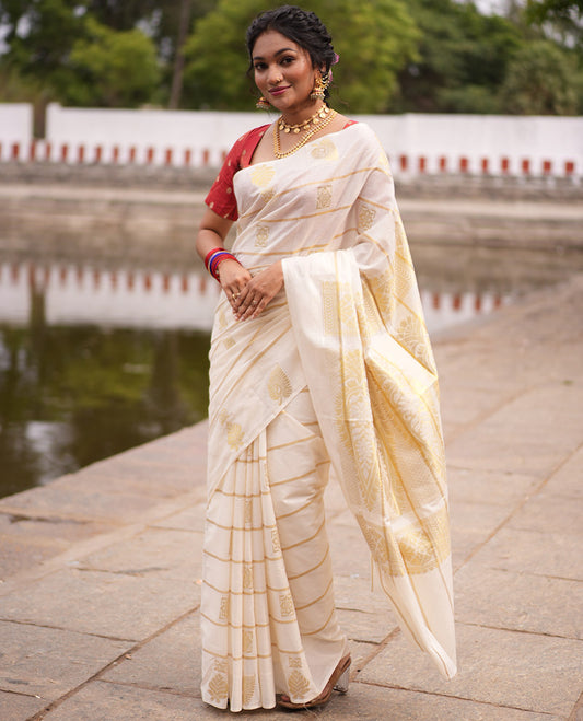 Cream Kerala Cotton Saree, Delicately Woven with Zari Stripes and Buttas, Highlighted by an Intricate Pallu and a Matching Blouse