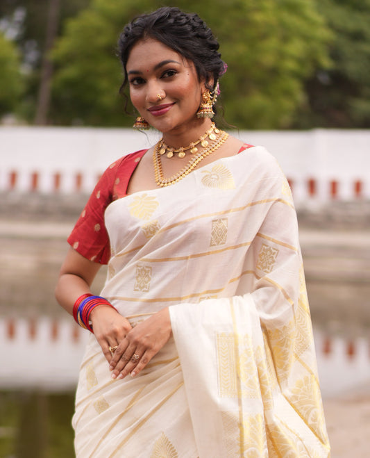 Cream Kerala Cotton Saree, Delicately Woven with Zari Stripes and Buttas, Highlighted by an Intricate Pallu and a Matching Blouse