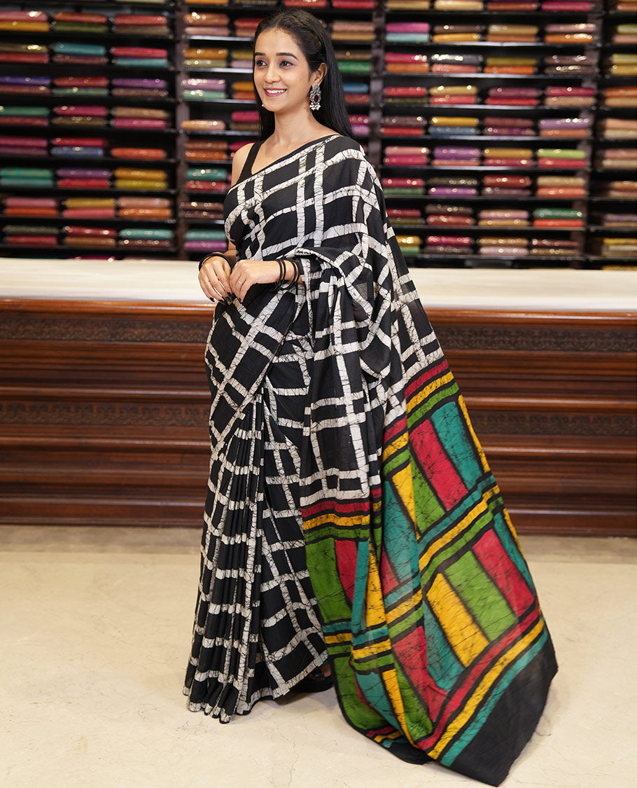 Black checked batik printed mul cotton saree, contrast kaleidoscope colored batik printed pallu, and a contrast batik printed blouse