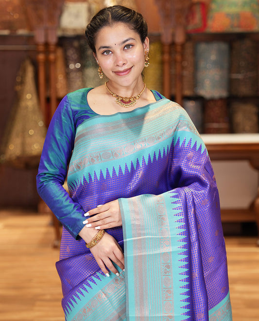 Blue Litchi Saree, Gracefully Embellished with Zari Buttas and Micro-Zari Checks on Its Body, Complemented by a Contrast Traditional Temple Border of Peacock and Rudraksham Designs, an Opulently Embellished Pallu, and Paired with a Contrast Blouse