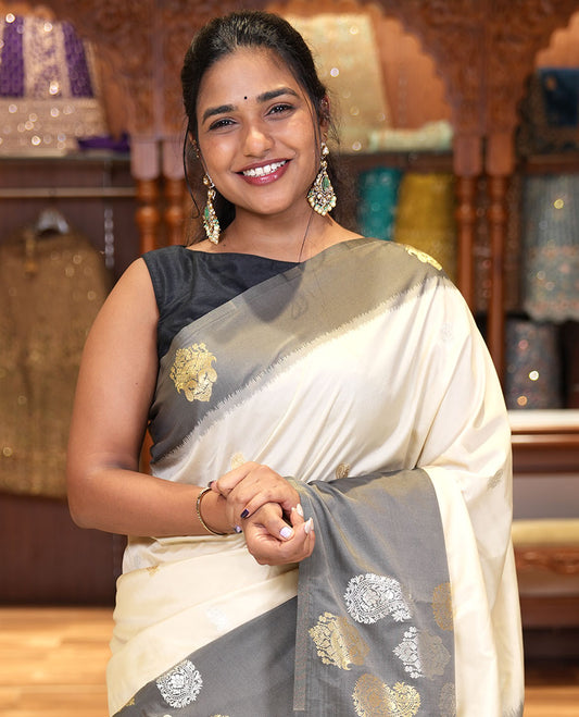 Cream Elite Soft Silk Saree, Accentuated with Zari Buttas All Over Its Body, Complemented by Contrast Border Steeped with Zari Buttas, Grand Jaal Design Pallu, and Paired with a Contrast Blouse
