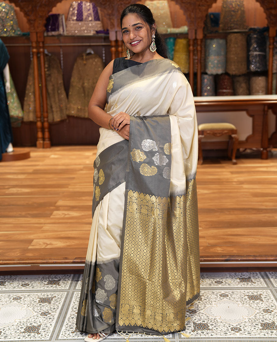 Cream Elite Soft Silk Saree, Accentuated with Zari Buttas All Over Its Body, Complemented by Contrast Border Steeped with Zari Buttas, Grand Jaal Design Pallu, and Paired with a Contrast Blouse
