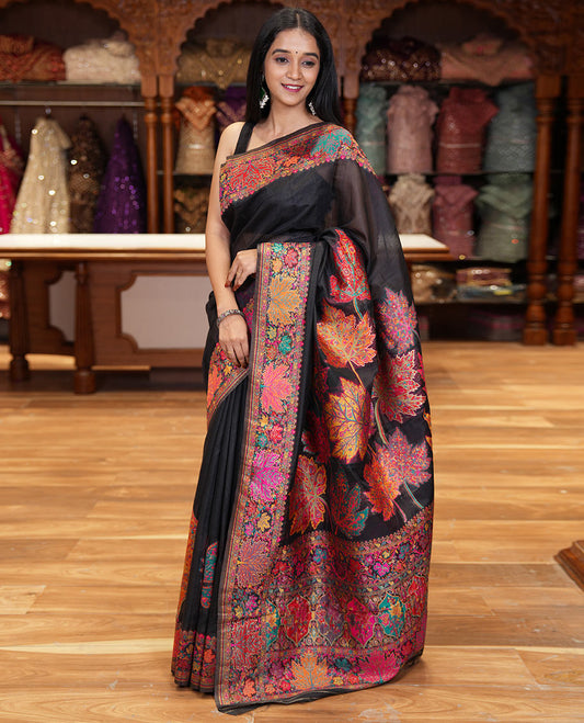 Black kaleidoscopic floral motifs woven pashmina saree, kaleidoscopic floral border, Mughal style patterned pallu, and a colorful leaf jaal blouse
