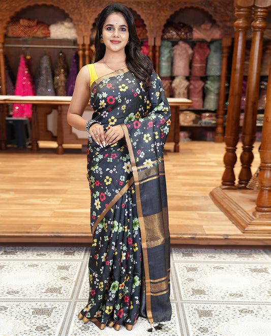 Black colorful floral printed banana pith saree, piping zari border, zari decked pallu, and a contrast floral printed blouse
