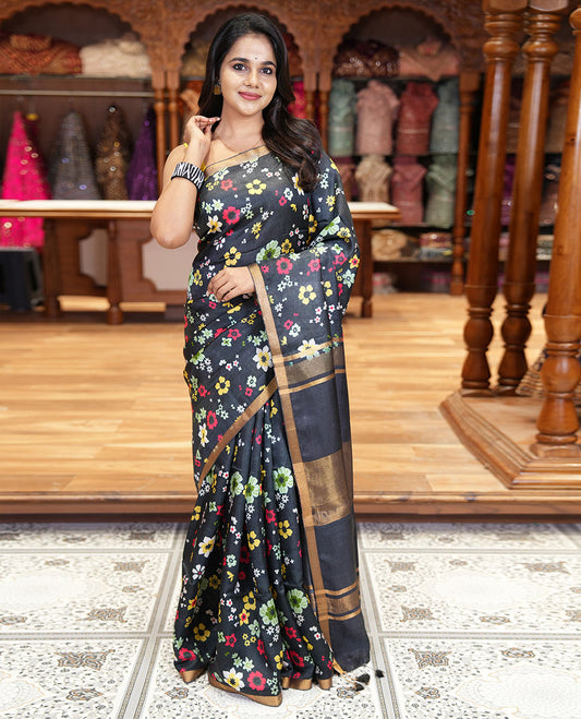 Black colorful floral printed banana pith saree, piping zari border, zari decked pallu, and a contrast floral printed blouse