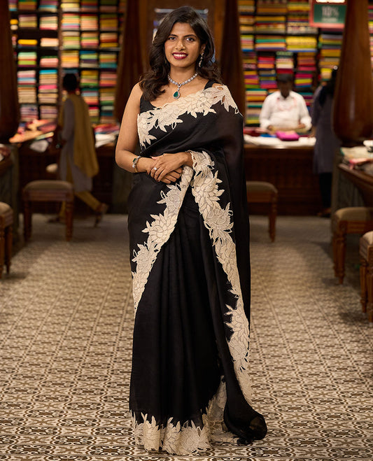 Black organza saree with contrast floral embroidery, cut work border