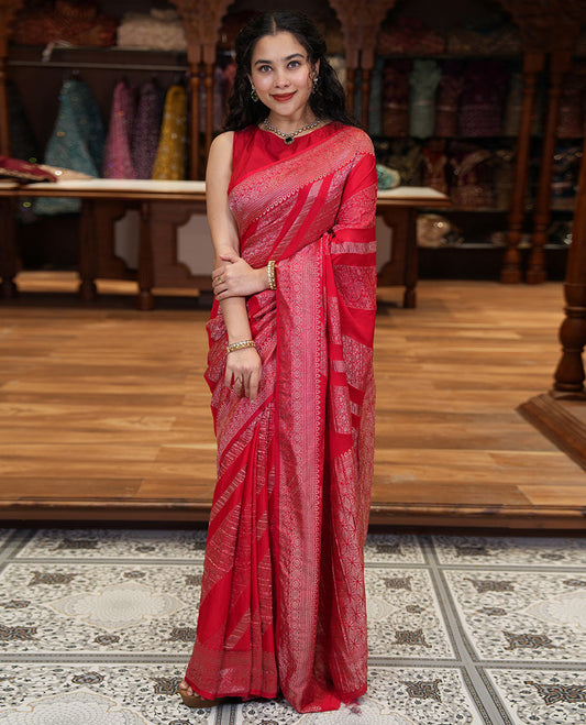 Red geometric and intricate designs zari woven fancy crepe saree, traditional zari border, floral-star gridded pallu, and a matching blouse