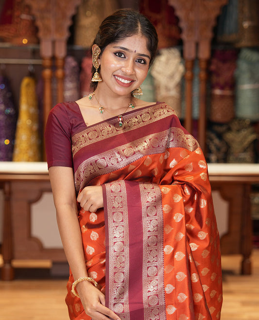 Rust orange zari buttas kanchi silk saree, contrast traditional rettai pettu border of peacock chakram, intricate pallu, and a zari design pallu