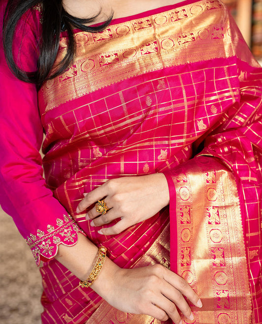 Pink Vasundhara Silk Saree Gracefully Embellished with Zari Butta Enclosed Checks, Complemented with a Zari Border of Kuthirai and Chakram Designs, Pallu of Intricate Zari-Weave, and Paired with a Matching Blouse